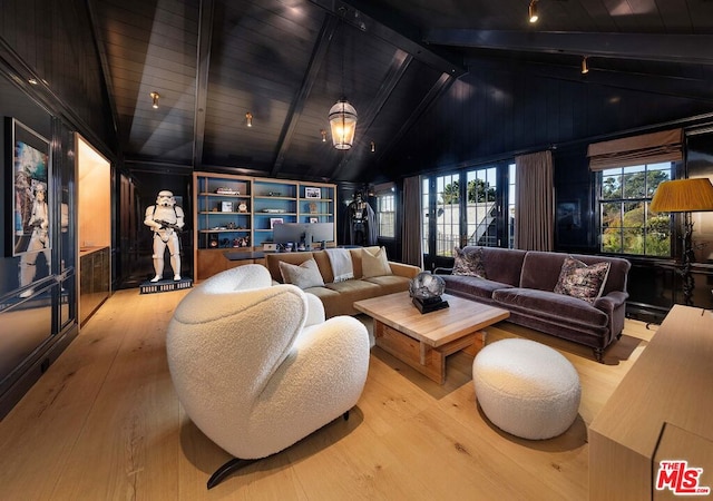 home theater with a healthy amount of sunlight, vaulted ceiling with beams, and wood-type flooring