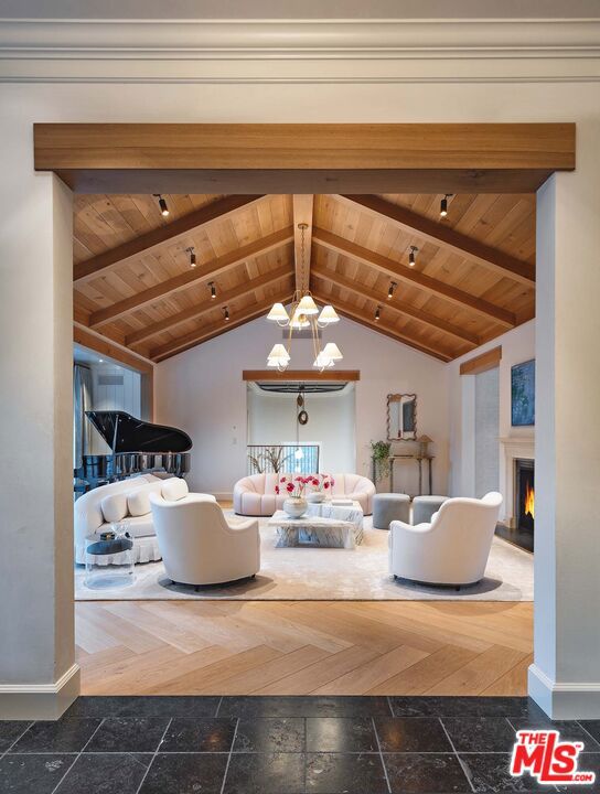 interior space with wooden ceiling, vaulted ceiling with beams, and an inviting chandelier