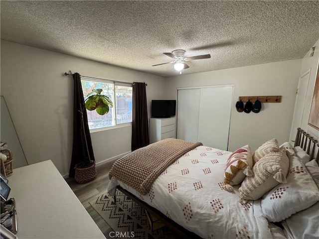 bedroom featuring ceiling fan, hardwood / wood-style floors, a closet, and a textured ceiling