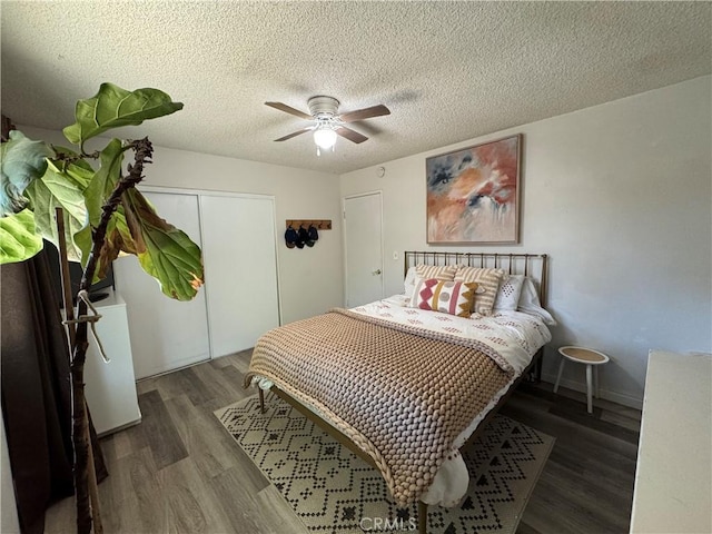 bedroom featuring ceiling fan, dark wood-type flooring, a textured ceiling, and a closet