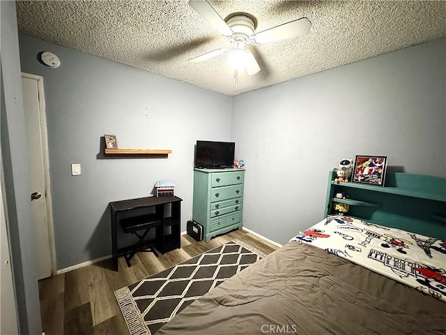 bedroom featuring light hardwood / wood-style floors, a textured ceiling, and ceiling fan