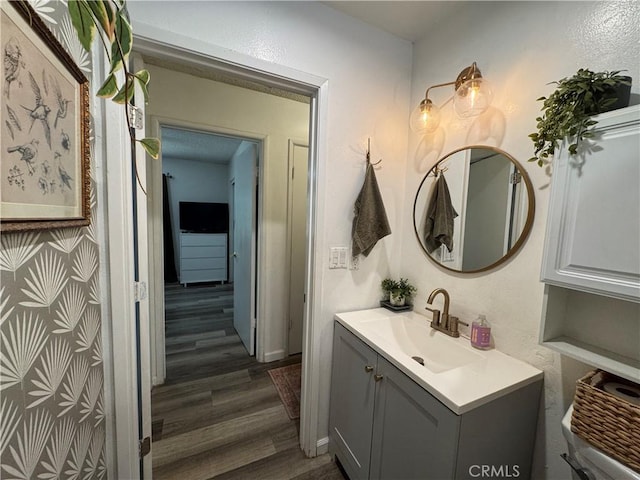 bathroom featuring wood-type flooring, toilet, and vanity