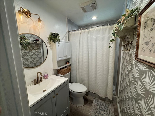 bathroom featuring vanity, toilet, walk in shower, and hardwood / wood-style flooring