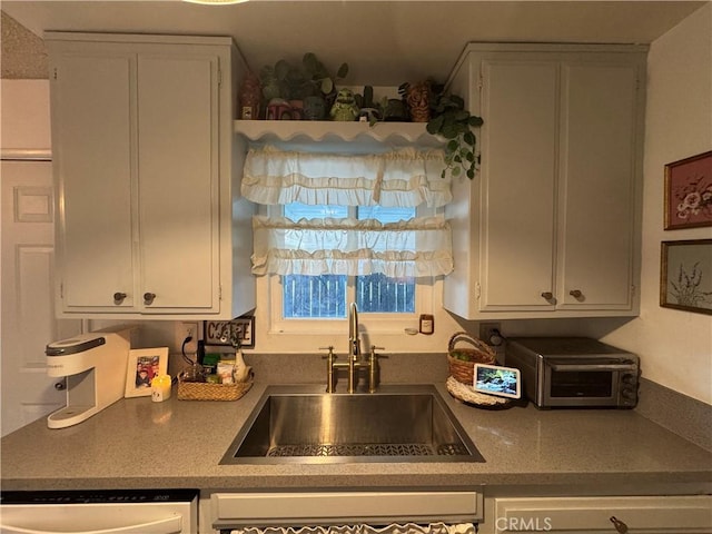 kitchen featuring sink and white cabinetry