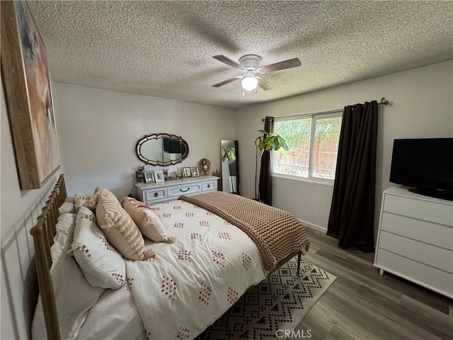 bedroom featuring ceiling fan, a textured ceiling, and dark hardwood / wood-style flooring