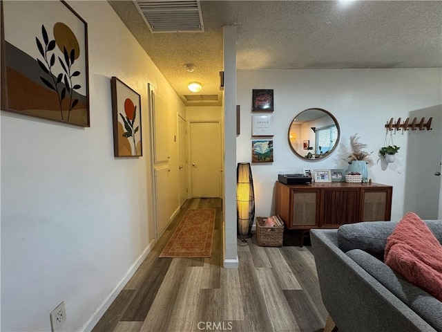 corridor featuring a textured ceiling and hardwood / wood-style floors