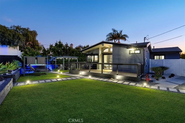 yard at dusk featuring a deck