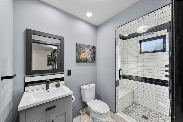 bathroom with toilet, tasteful backsplash, walk in shower, and vanity