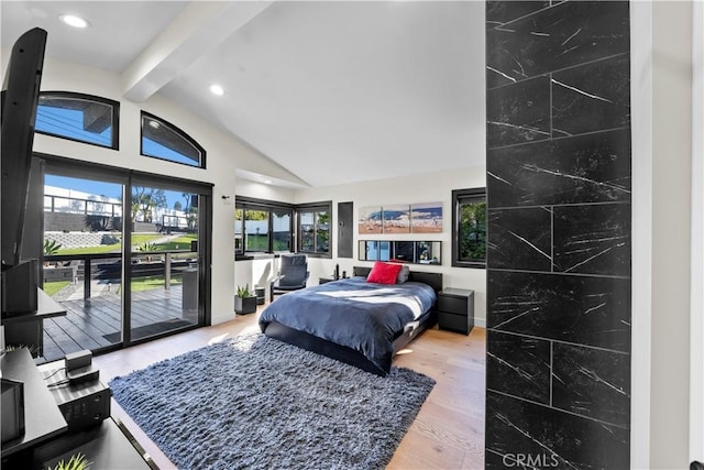 bedroom featuring hardwood / wood-style flooring, lofted ceiling with beams, multiple windows, and access to outside