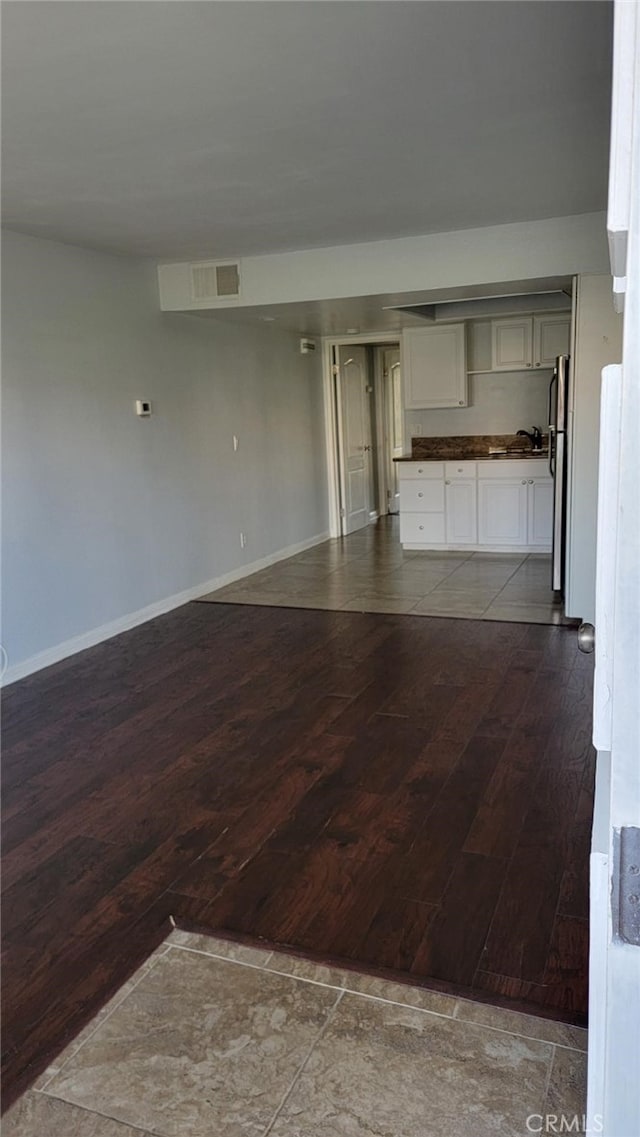 unfurnished living room featuring sink and hardwood / wood-style floors