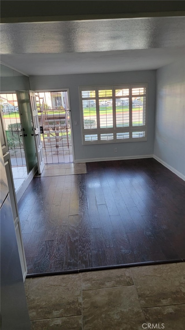 unfurnished room featuring dark hardwood / wood-style flooring and a wealth of natural light