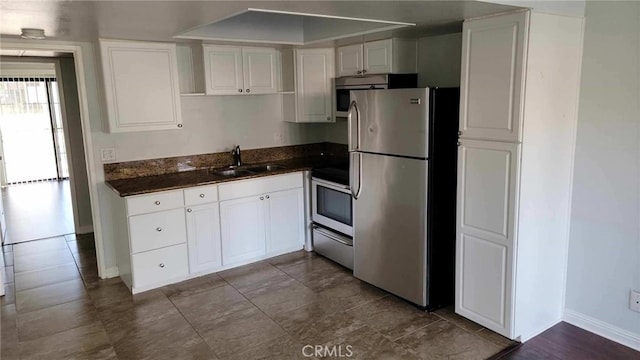 kitchen featuring white cabinetry, sink, dark stone counters, and appliances with stainless steel finishes