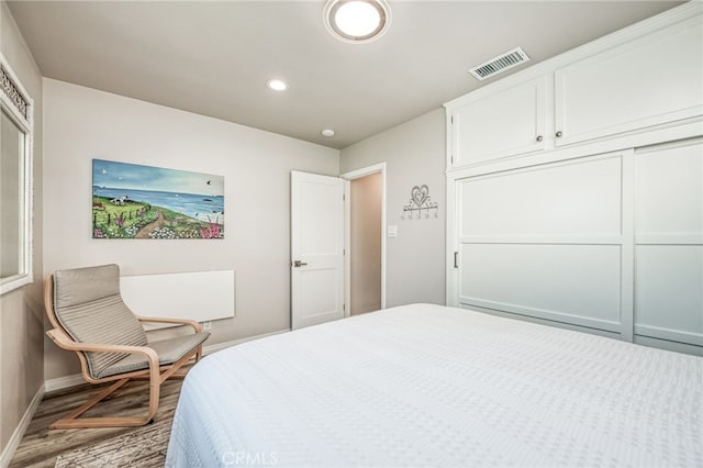 bedroom with a closet and hardwood / wood-style floors