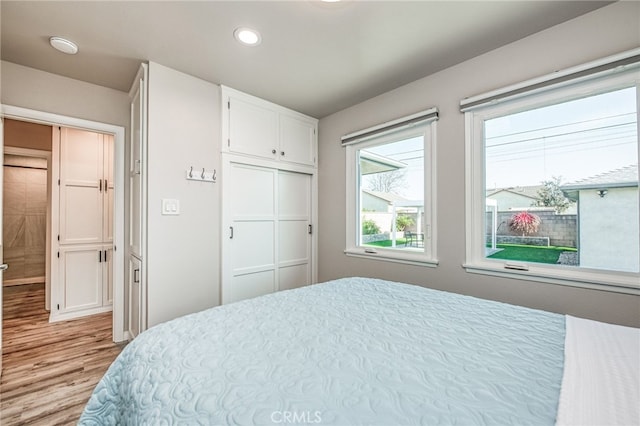 bedroom with light wood-type flooring and a closet