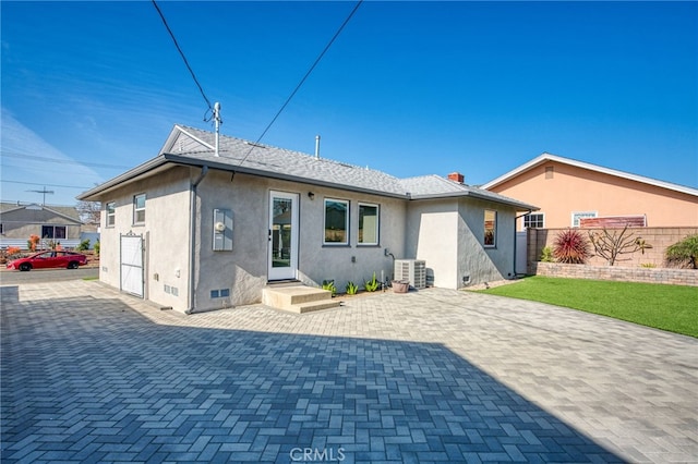 rear view of property with central air condition unit and a patio area