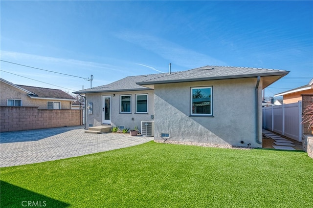 back of property featuring cooling unit, a patio, and a yard