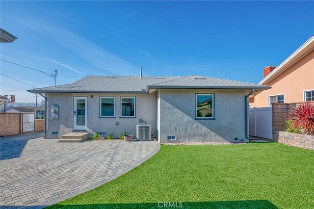 rear view of house with central AC, a yard, and a patio