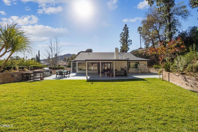 rear view of house featuring a patio area and a lawn