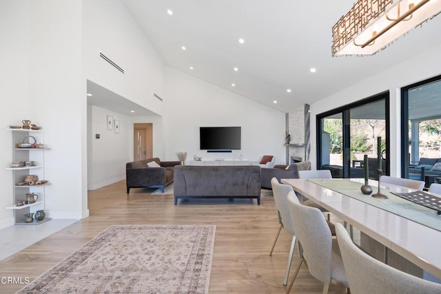 living room featuring light wood-type flooring and high vaulted ceiling