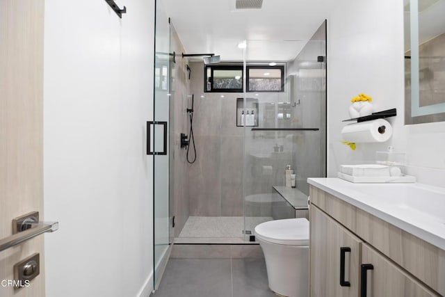 bathroom with tile patterned flooring, toilet, vanity, and walk in shower