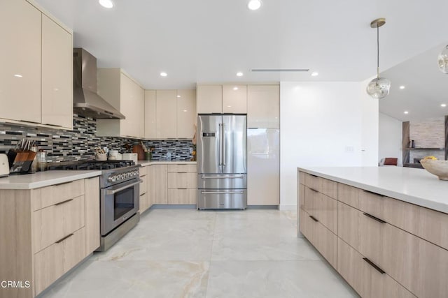 kitchen featuring decorative light fixtures, backsplash, stainless steel appliances, wall chimney exhaust hood, and light brown cabinets