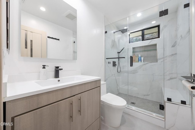 bathroom with a shower with door, toilet, and vanity