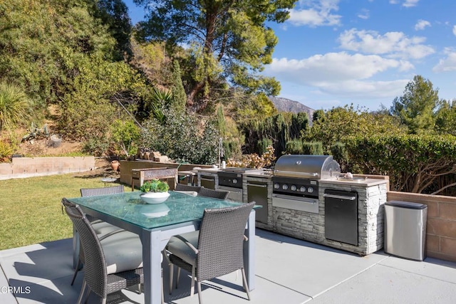 view of patio with a mountain view, a grill, and area for grilling