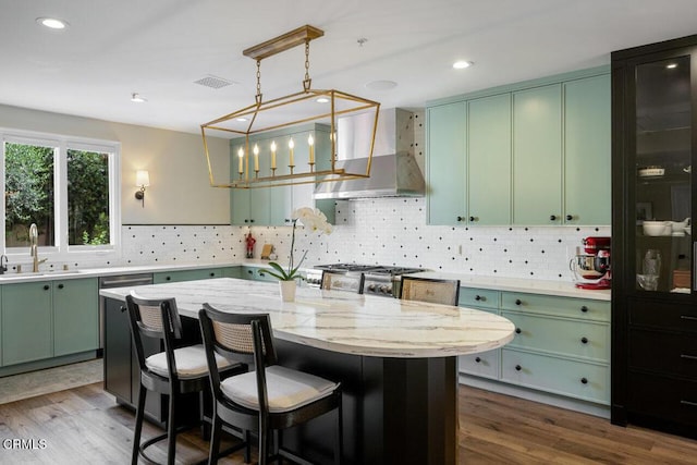 kitchen featuring extractor fan, stove, sink, a kitchen island, and light stone counters