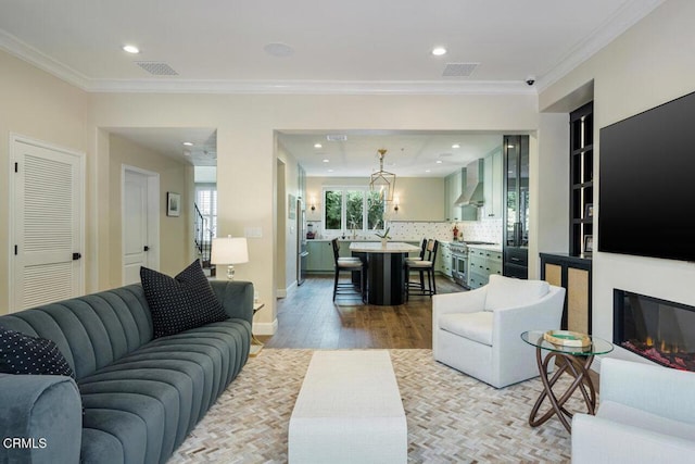 living room with crown molding and light wood-type flooring