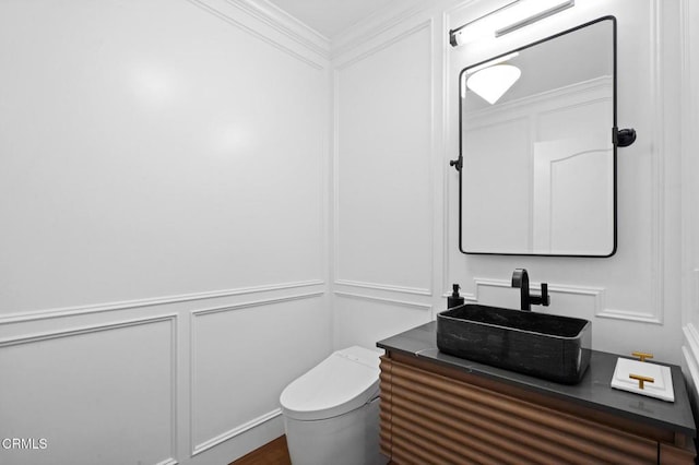 bathroom featuring crown molding, toilet, and vanity