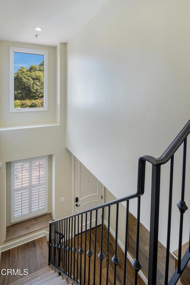 stairway with hardwood / wood-style floors and a healthy amount of sunlight