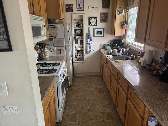 kitchen with sink, white appliances, and stone counters