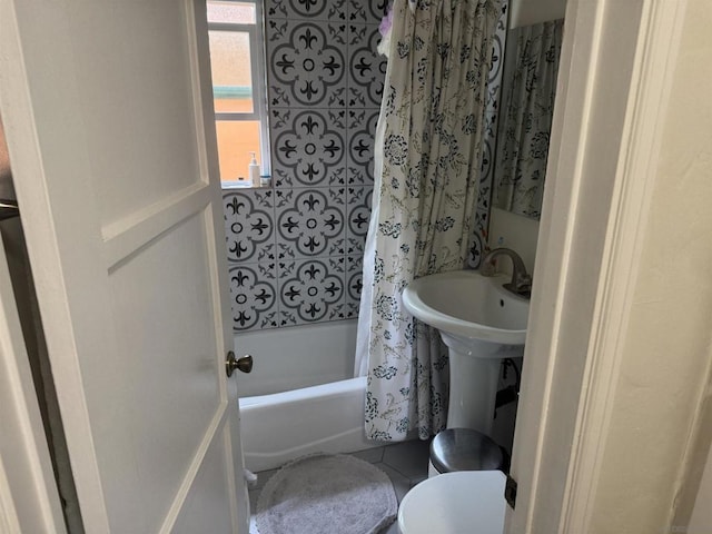 bathroom featuring toilet, shower / bathtub combination with curtain, and tile patterned flooring