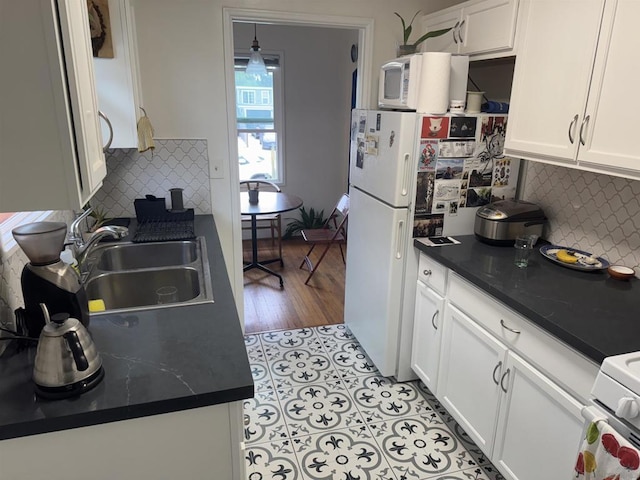 kitchen featuring sink, white cabinetry, and backsplash