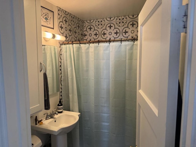 bathroom featuring sink, toilet, and curtained shower