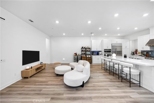 living room with sink and light hardwood / wood-style flooring