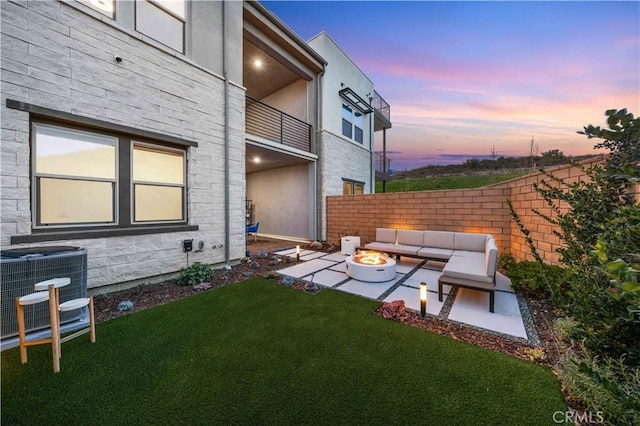 yard at dusk with a patio, central AC, and an outdoor living space with a fire pit