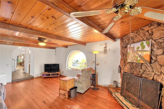 unfurnished living room with ceiling fan, wooden ceiling, beam ceiling, and light wood-type flooring