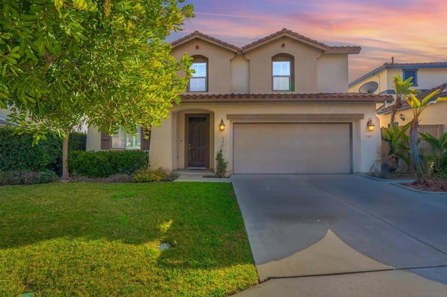 mediterranean / spanish-style house with a garage and a lawn