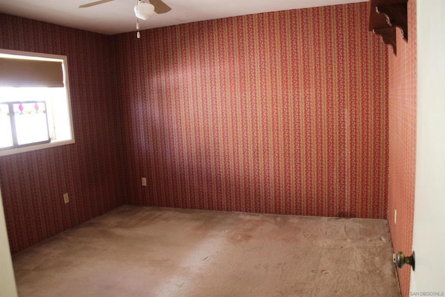 unfurnished room with ceiling fan and carpet