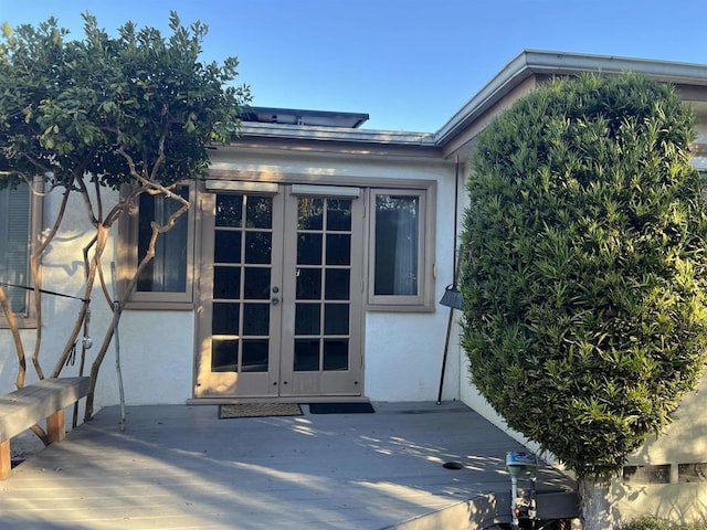 property entrance featuring a deck and french doors