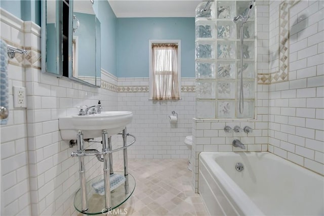 bathroom with tile patterned floors, tile walls, toilet, and tiled shower / bath combo