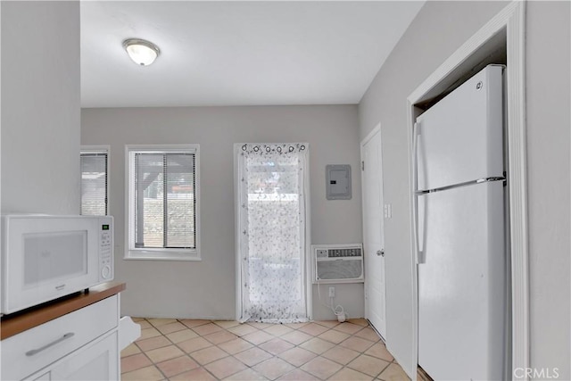 kitchen featuring white cabinets, white appliances, light tile patterned floors, and a wall unit AC