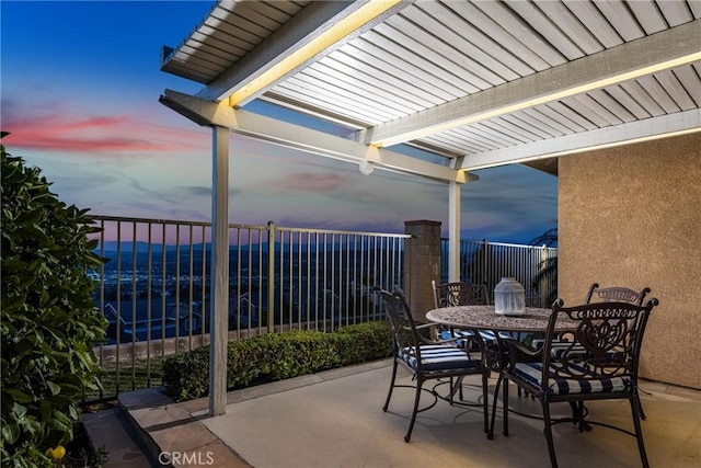 patio terrace at dusk featuring a pergola