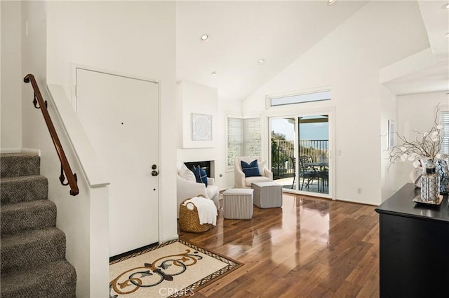 foyer with high vaulted ceiling and wood-type flooring