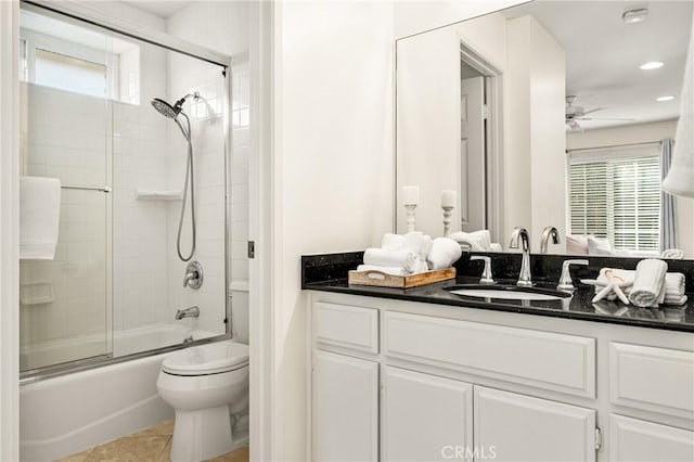 full bathroom featuring tile patterned floors, ceiling fan, combined bath / shower with glass door, toilet, and vanity