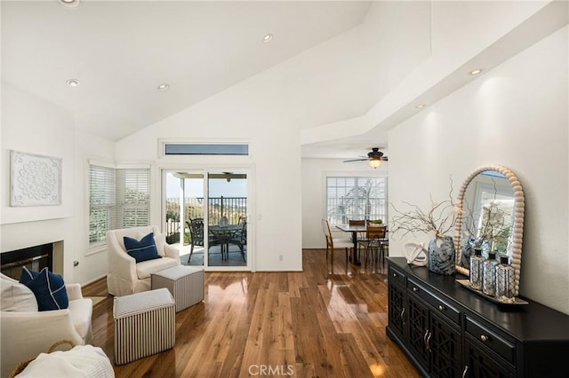 sitting room featuring ceiling fan, high vaulted ceiling, and dark wood-type flooring