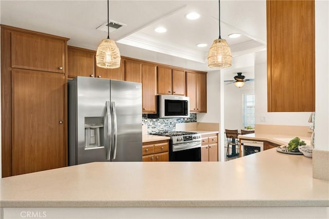 kitchen with sink, tasteful backsplash, hanging light fixtures, and stainless steel appliances