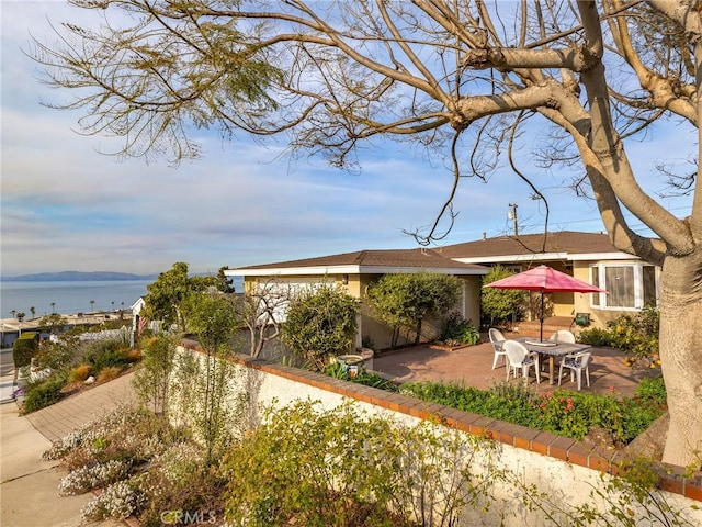 view of yard with a water view and a patio area