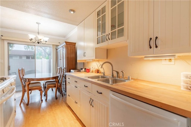 kitchen with pendant lighting, white dishwasher, sink, and white cabinets